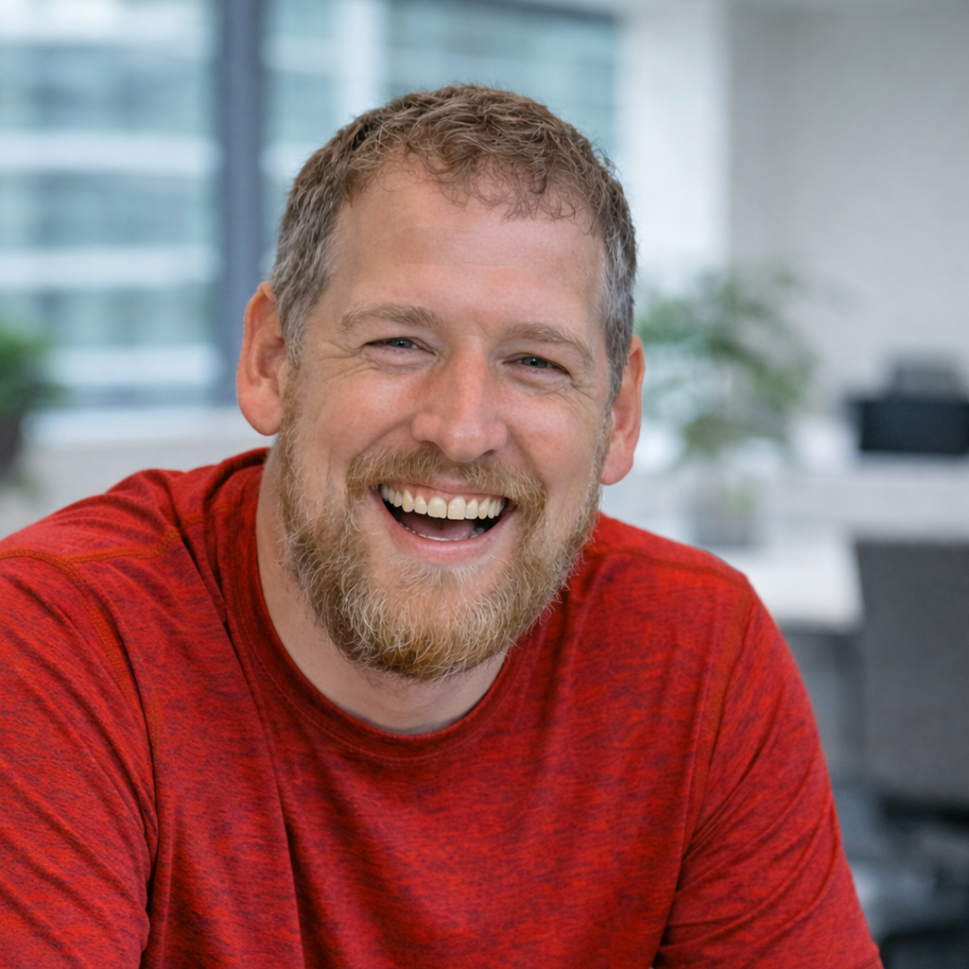 Close up portrait of Jamie McAnsh smiling warmly in a professional office environment